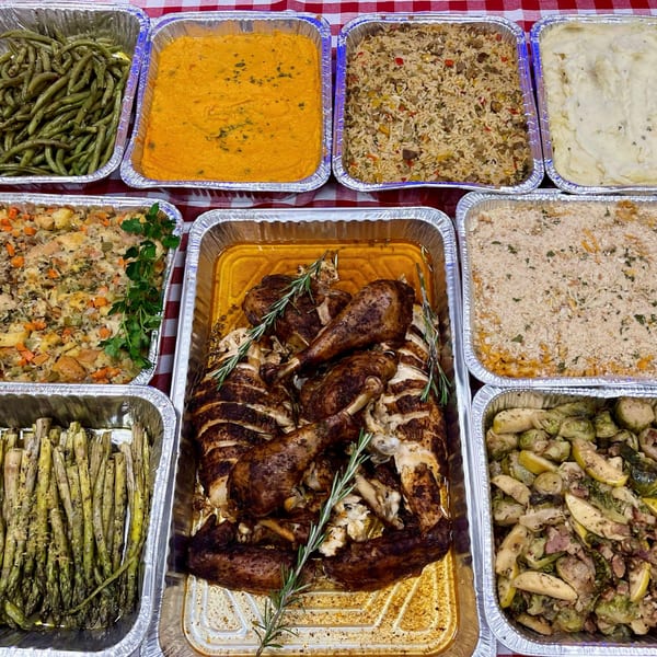 A Top Butcher Market catering spread with roasted turkey, green beans, mashed potatoes, stuffing, and more.