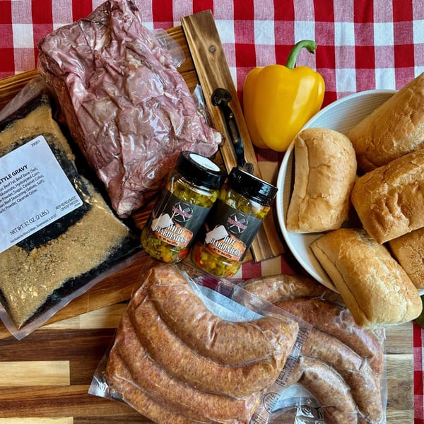 Top Butcher Market products: vacuum-sealed meats, gravy, giardiniera, and bread rolls on a red checkered cloth.